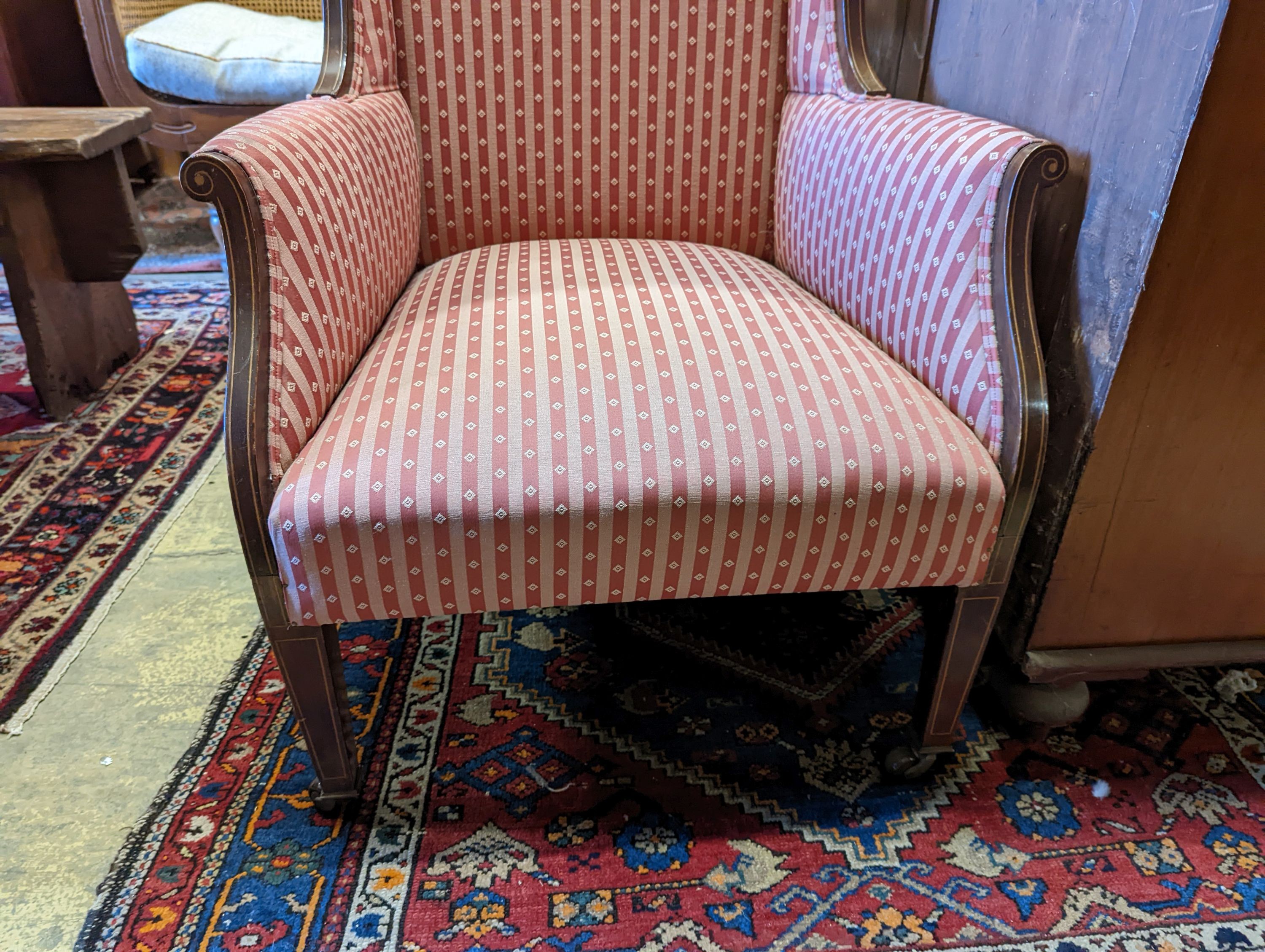 An Edwardian inlaid armchair with scrolled frame